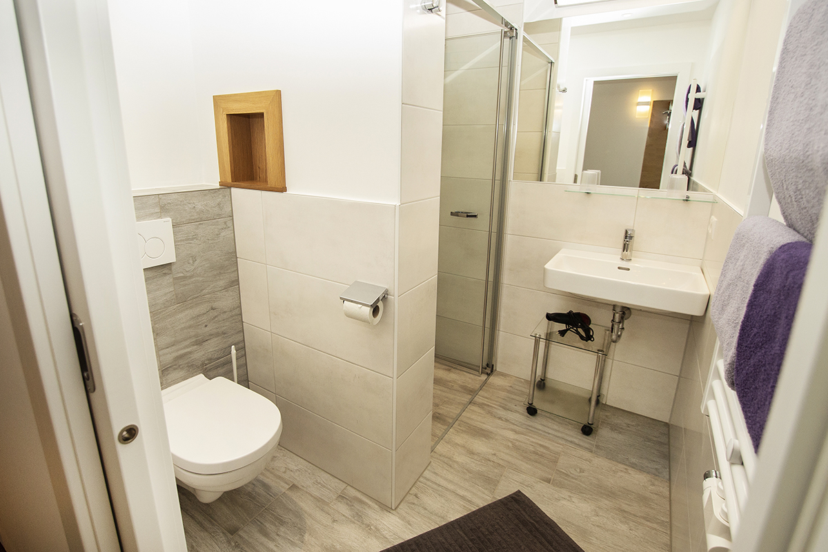 1 von 3 Badezimmern - Apartment D+